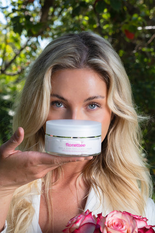 Model holding Florettee Rose Oil BB Hand & Body Cream with fresh roses.