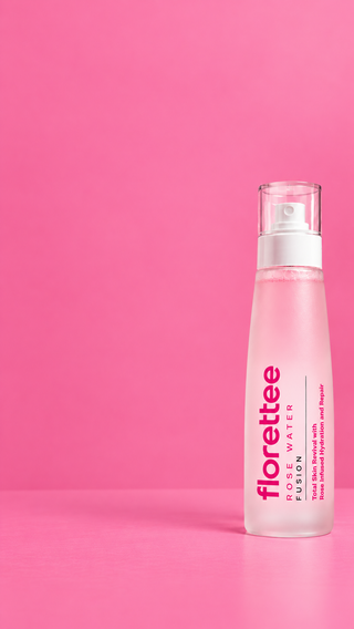 A frosted glass bottle of Florette Fusion Rose Water with a white pump dispenser, set against a solid pink background.